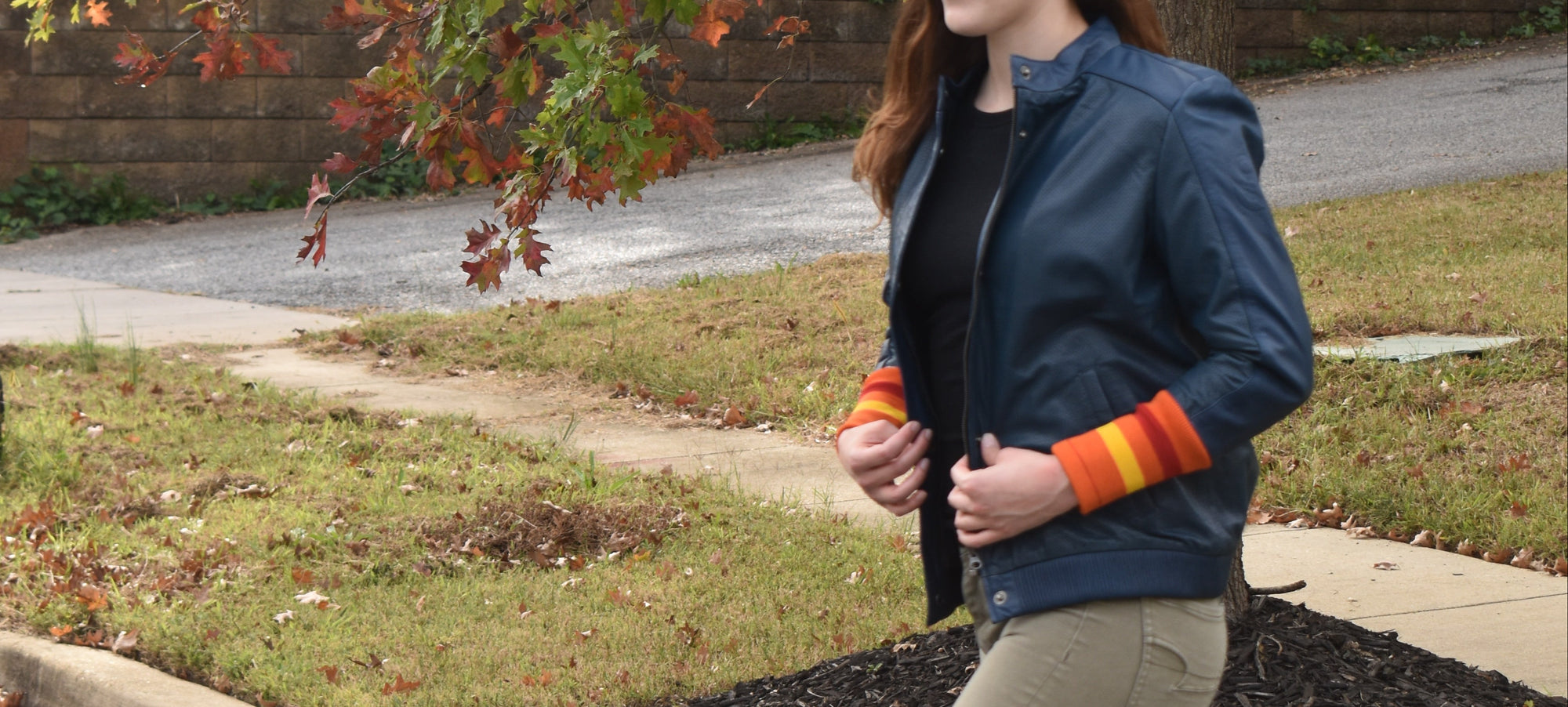 Person walking on a road with trees and grass in the background